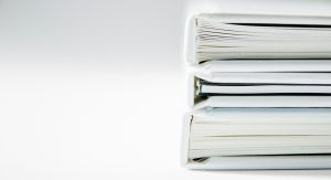 A stack of white folders on a white surface